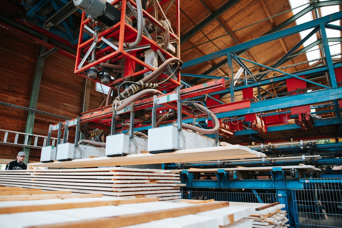 Holzbretter auf einer Fördervorrichtung in der Werkshalle